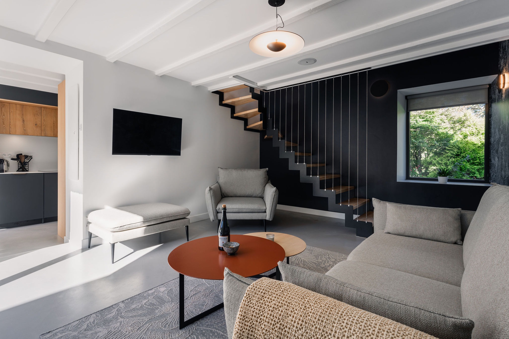 Salon contemporain du logement Le Recouvrance, logement de standing au Domaine de Stang Bihan à Concarneau, avec mobilier design, vue sur la mer, accès à une piscine chauffée, à la côte et au chemin côtier.
