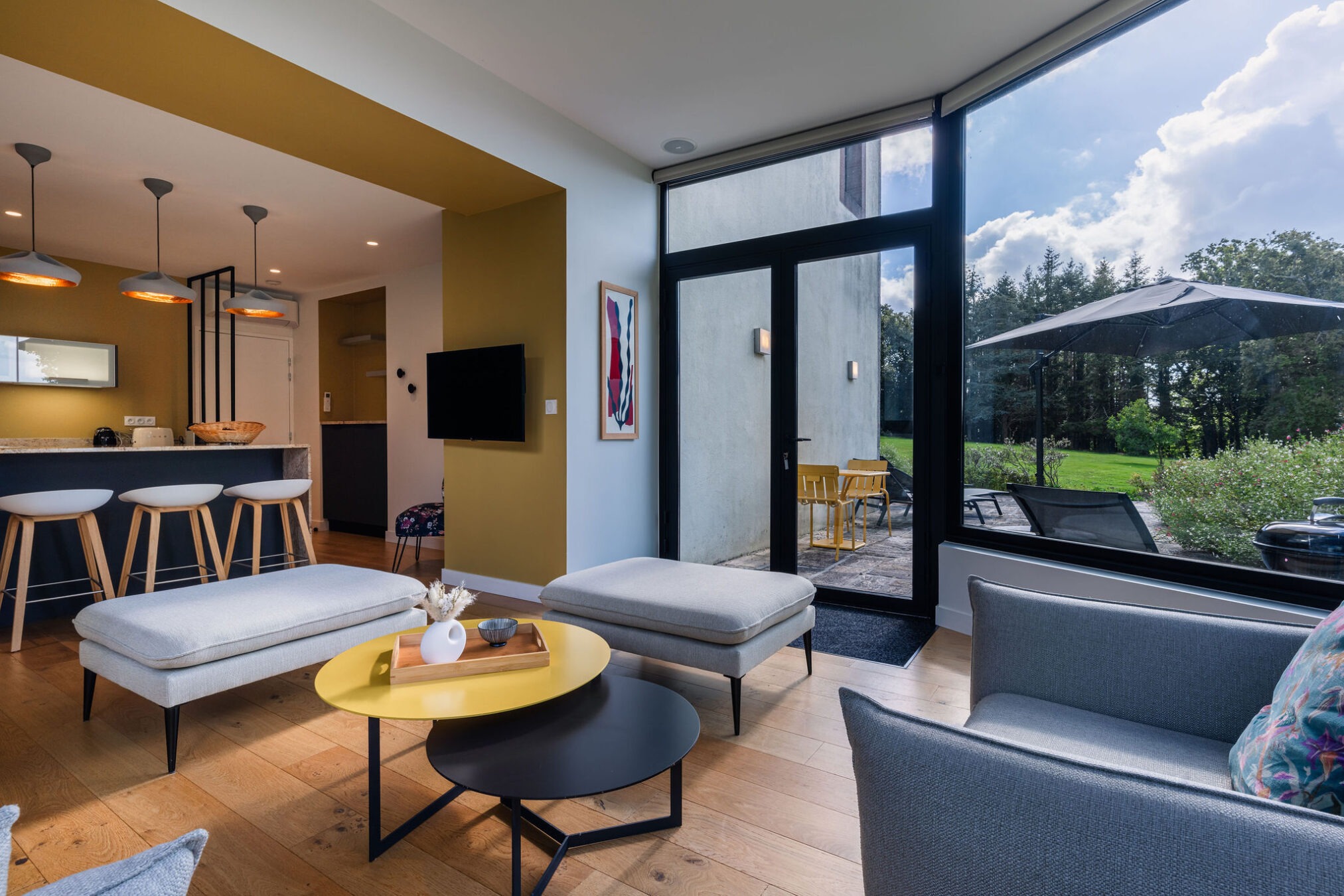 Salon moderne de l'appartement Le Corentin avec larges baies vitrées donnant sur une terrasse, vue mer panoramique à 180° sur les Glénan, dans le domaine de Stang Bihan à Concarneau.