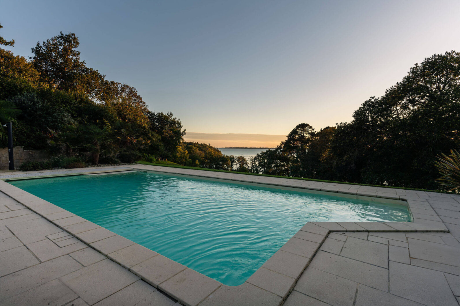 Piscine surplombant la mer au Domaine de Stang Bihan, avec vue dégagée sur l’océan Atlantique et la végétation environnante.