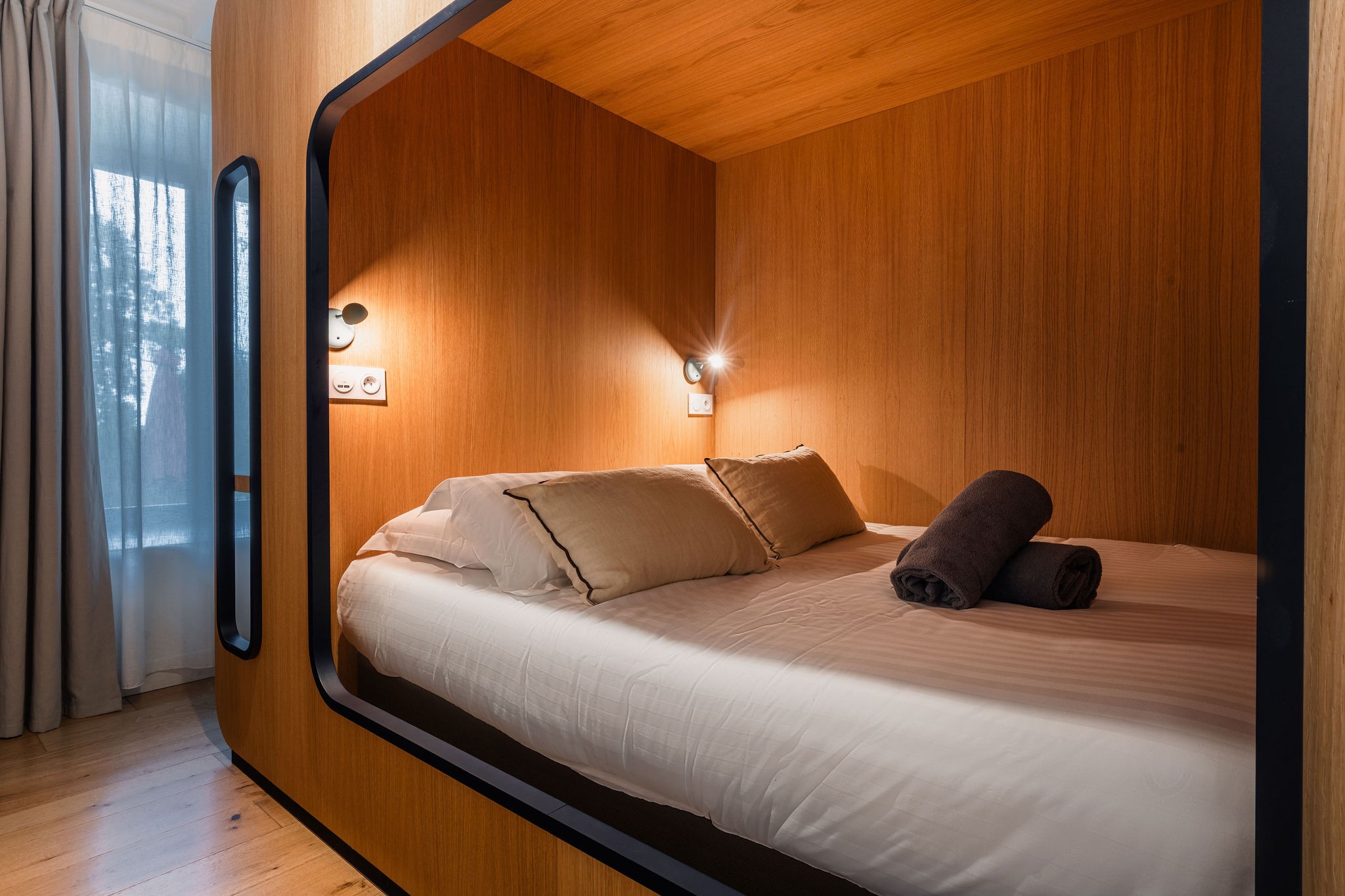 Design minimaliste d'une chambre capsule confortable.