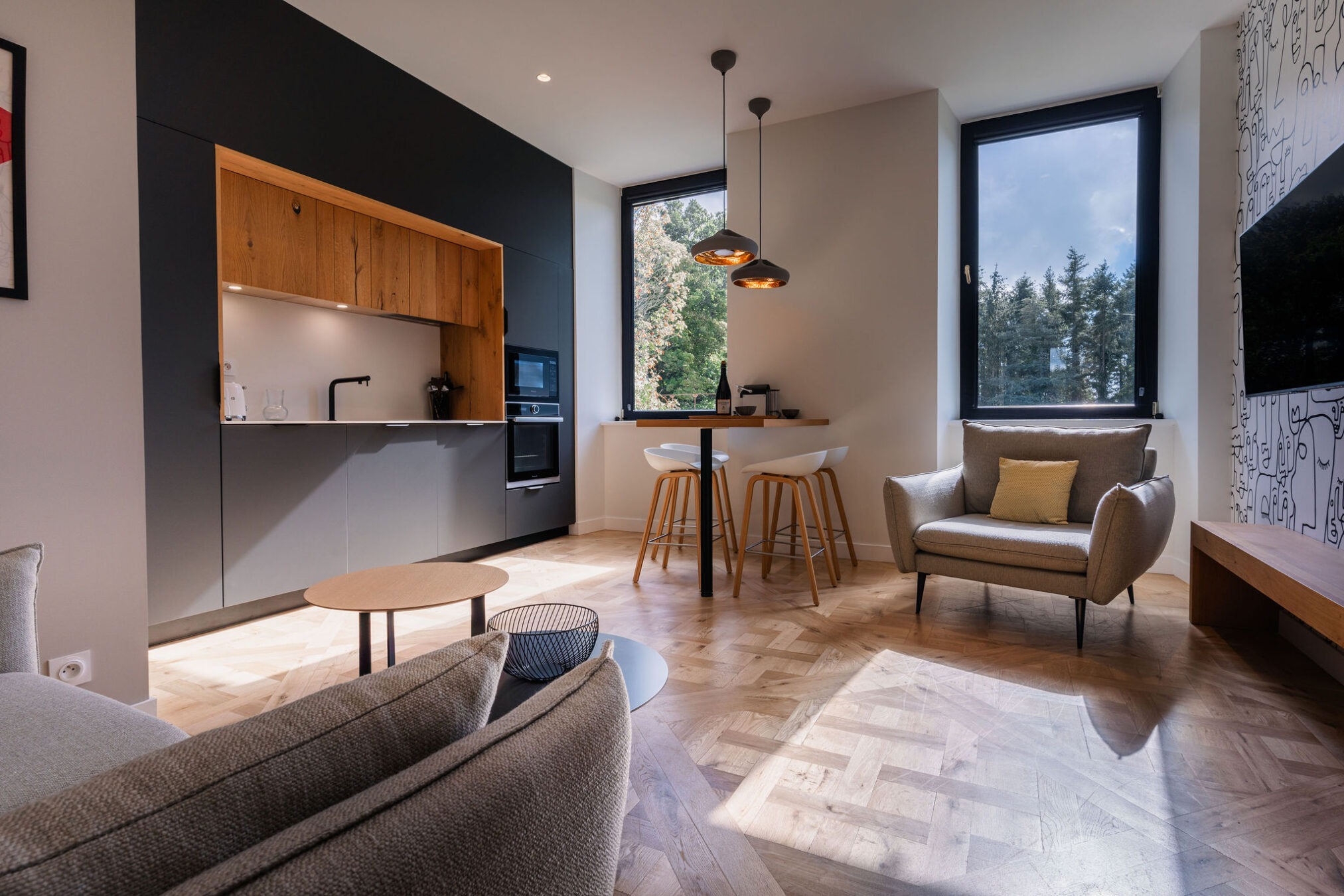 Salon moderne avec cuisine équipée dans l’appartement La Fée de l’Aulne au Domaine de Stang Bihan.