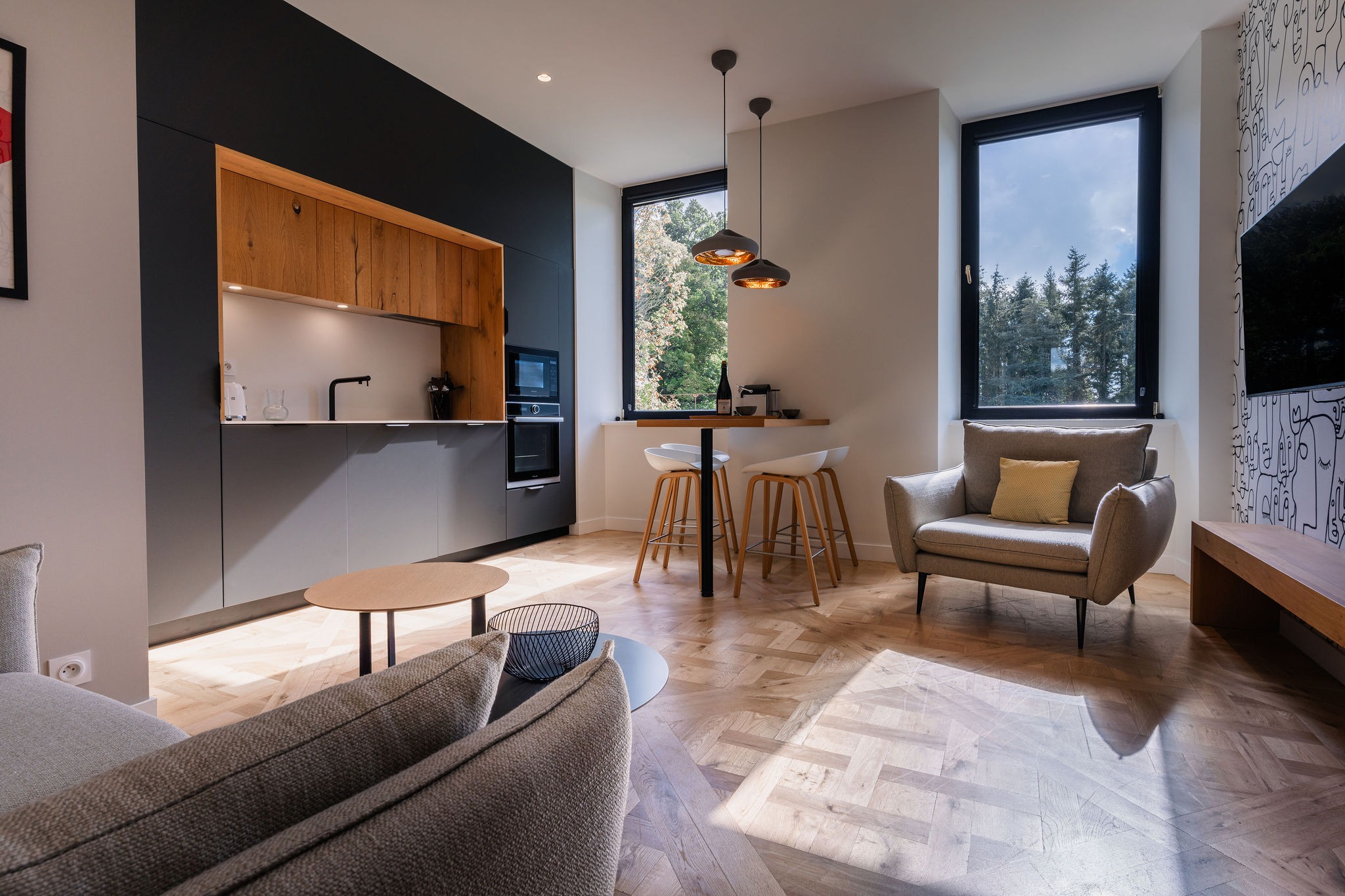 Salon moderne avec cuisine équipée dans l’appartement La Fée de l’Aulne au Domaine de Stang Bihan.