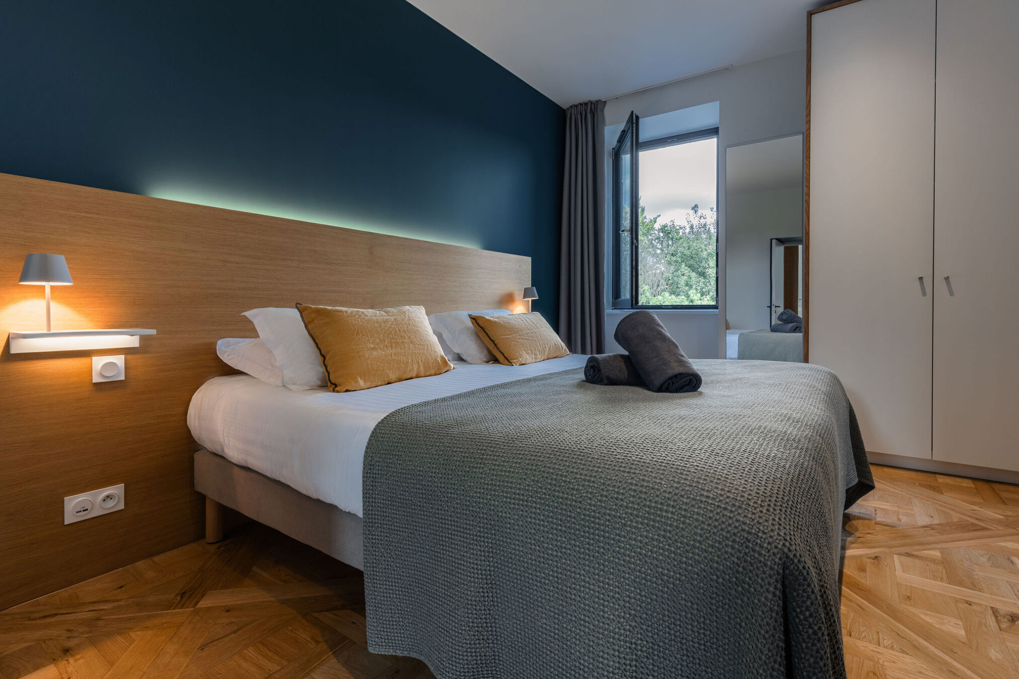 Chambre double élégante de l’appartement La Fée de l’Aulne, avec vue sur le parc.