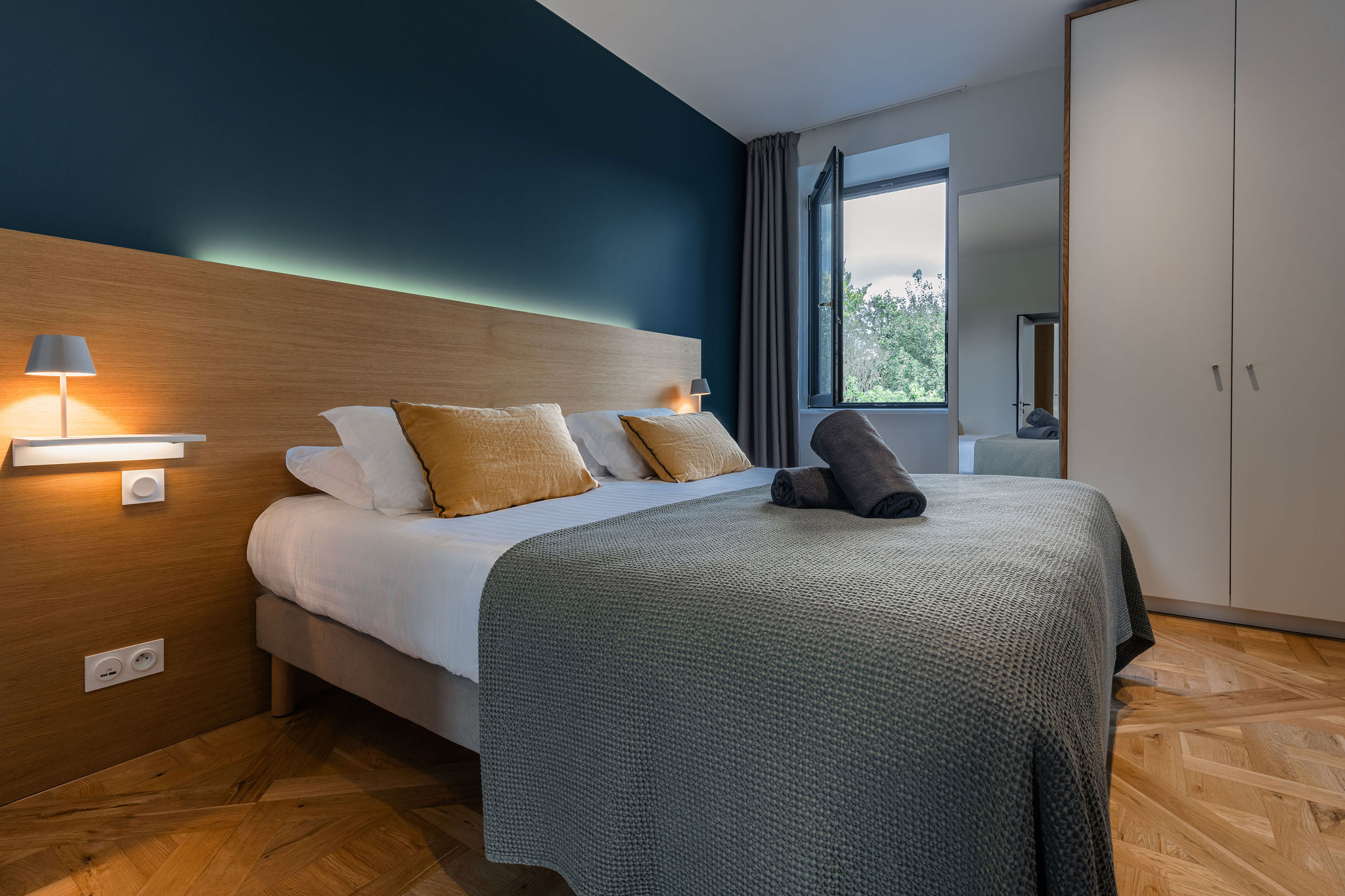 Chambre double élégante de l’appartement La Fée de l’Aulne, avec vue sur le parc.