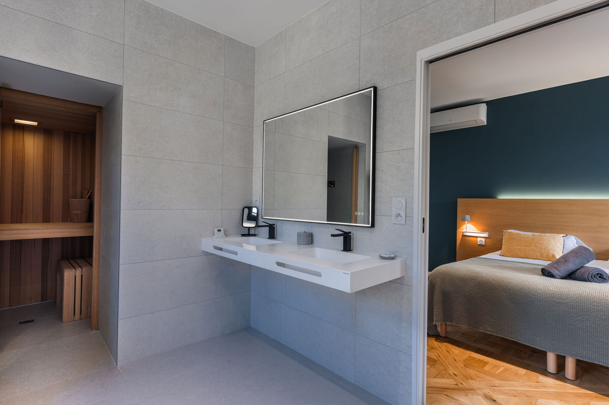 Vue sur la salle de bain contemporaine avec double vasque et sauna, donnant sur la chambre élégante de l’appartement La Fée de l’Aulne au Domaine de Stang Bihan