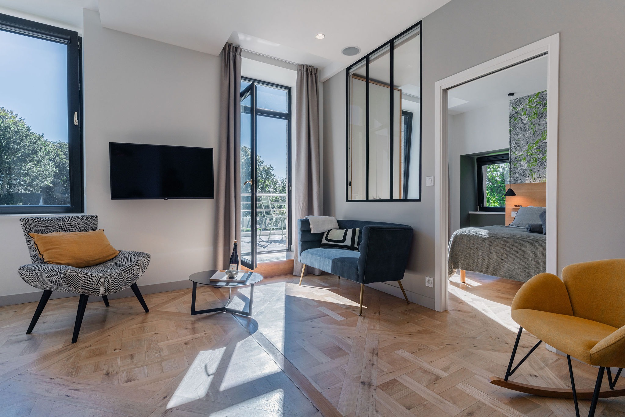 Salon lumineux avec fauteuils design, accès terrasse vue mer et chambre attenante – Appartement Le Biche, Domaine de Stang Bihan à Concarneau