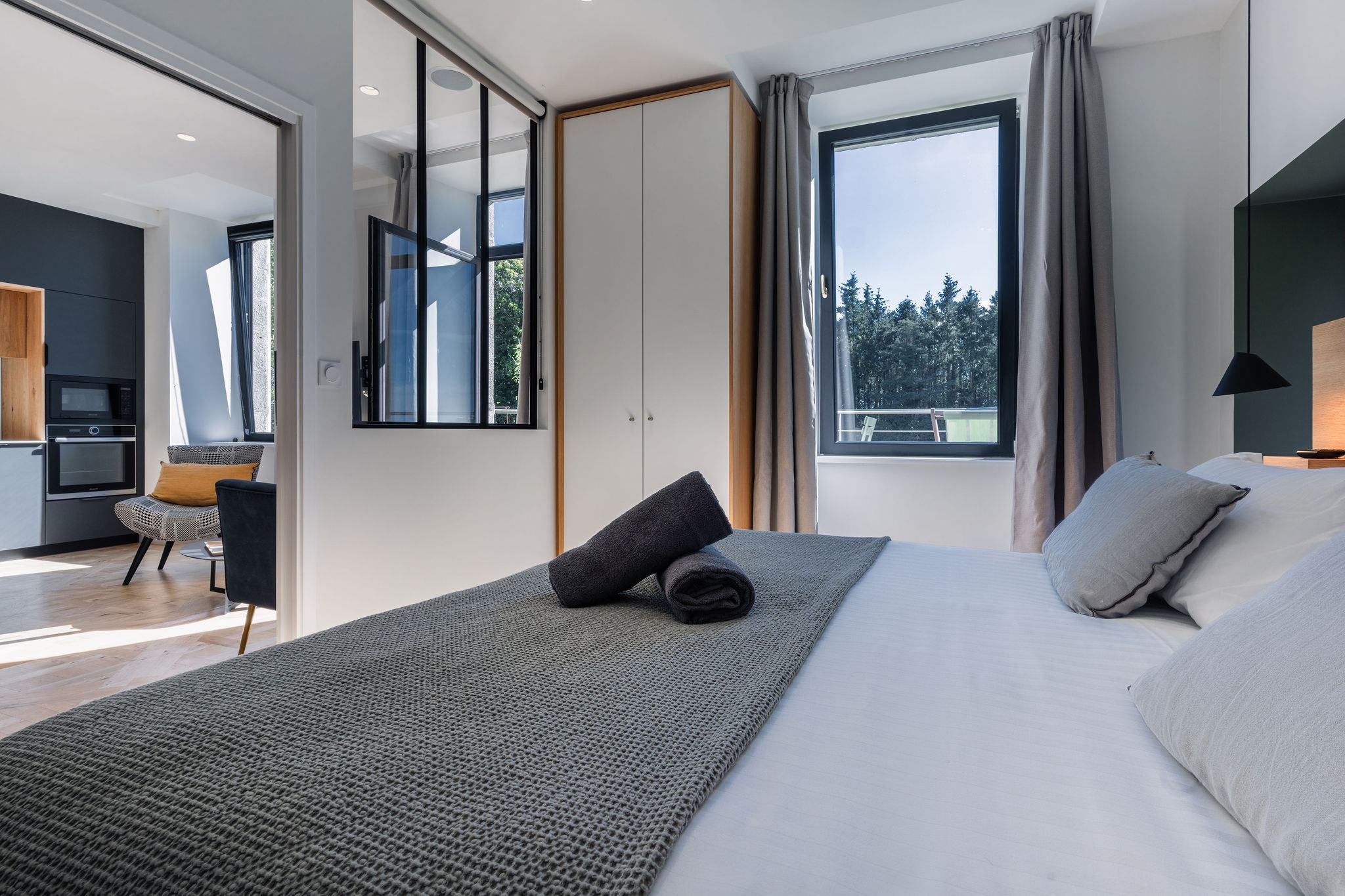 Chambre double lumineuse avec vue sur jardin et mer, verrière intérieure sur le salon – Appartement Le Biche, Domaine de Stang Bihan à Concarneau