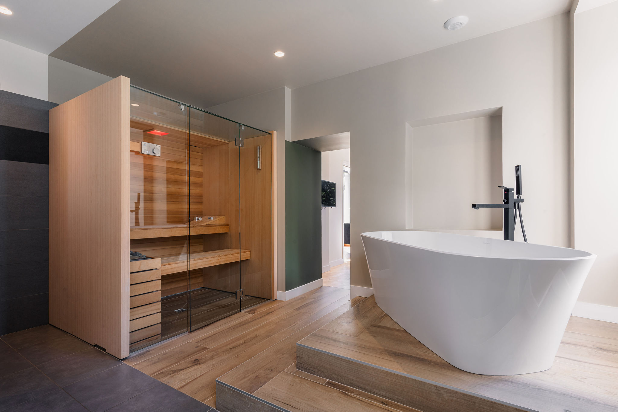 Salle de bain avec sauna en bois et baignoire design surélevée