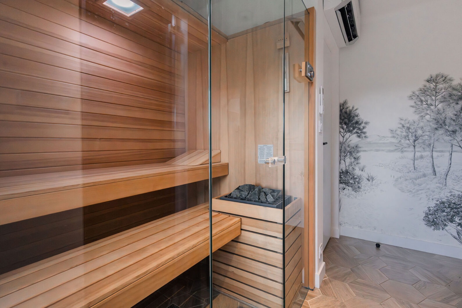 Sauna en bois avec parois vitrées et décoration murale nature
