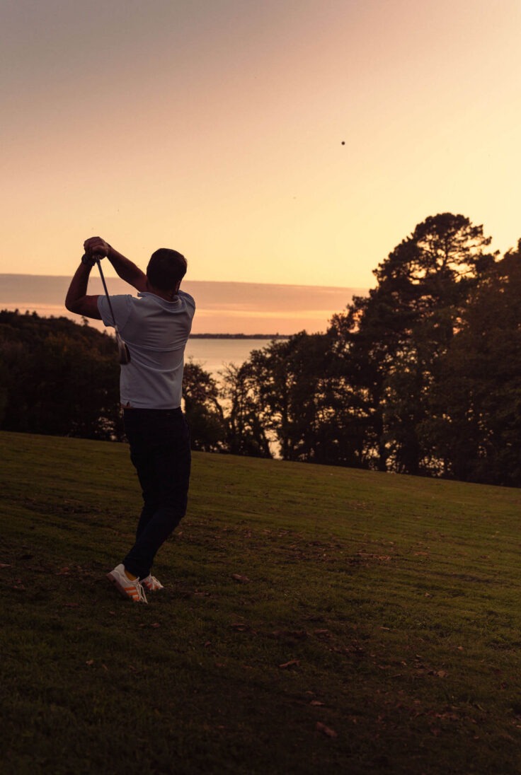 Joueur de golf au coucher du soleil au Domaine de Stang Bihan à Concarneau, en Bretagne.